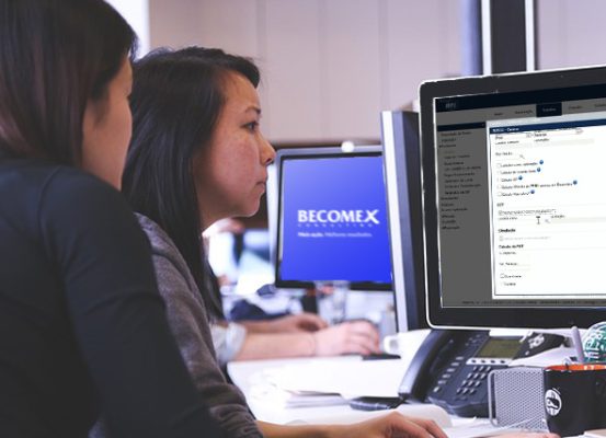 Profissionais utilizando sistema para gestão tributária com moeda funcional, sem depender do ERP, no ambiente corporativo da Becomex.