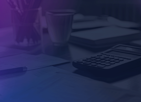 Mesa de trabalho com calculadora, canetas e documentos fiscais representando os desafios da consolidação de dados dentro da lei de Transfer Pricing