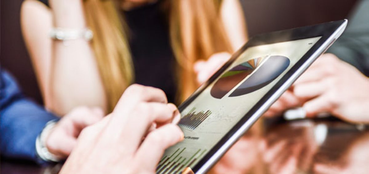 Especialistas da Becomex analisando gráficos em tablet para otimizar a gestão tributária de empresas por meio dos Regimes Especiais.
