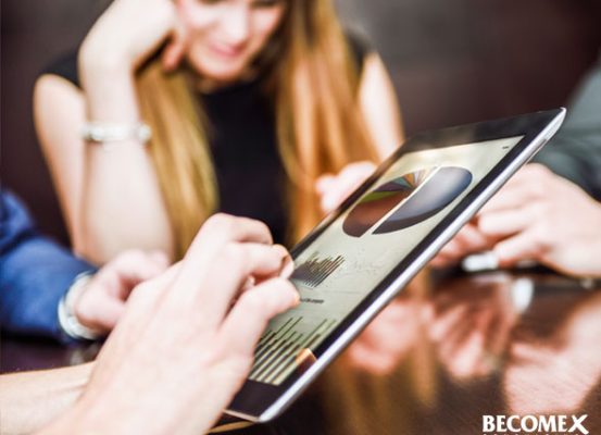 Especialistas da Becomex analisando gráficos em tablet para otimizar a gestão tributária de empresas por meio dos Regimes Especiais.