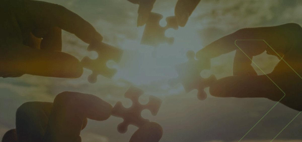 Mãos unindo peças de quebra-cabeça ao pôr do sol, representando estratégias tributárias colaborativas que agilizam o retorno do crescimento da indústria