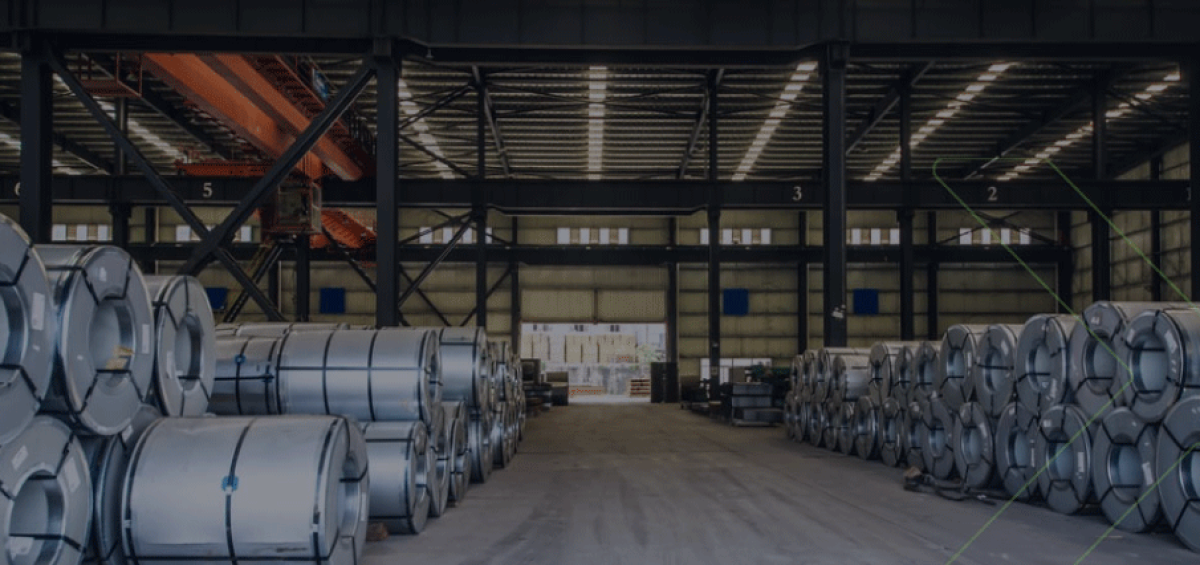 Armazém industrial com bobinas de aço organizadas, ilustrando a importância de uma estratégia fiscal inteligente como investimento necessário para a indústria.