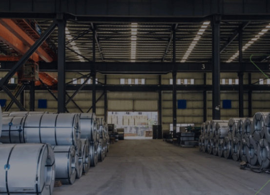 Armazém industrial com bobinas de aço organizadas, ilustrando a importância de uma estratégia fiscal inteligente como investimento necessário para a indústria.