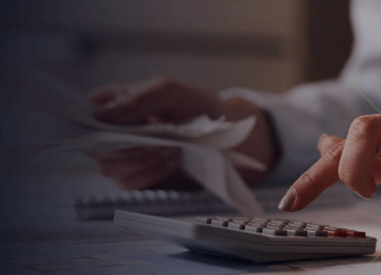 Profissional utilizando calculadora e analisando documentos fiscais, representando as novidades sobre a exclusão do ICMS da base de cálculo do PIS e COFINS.