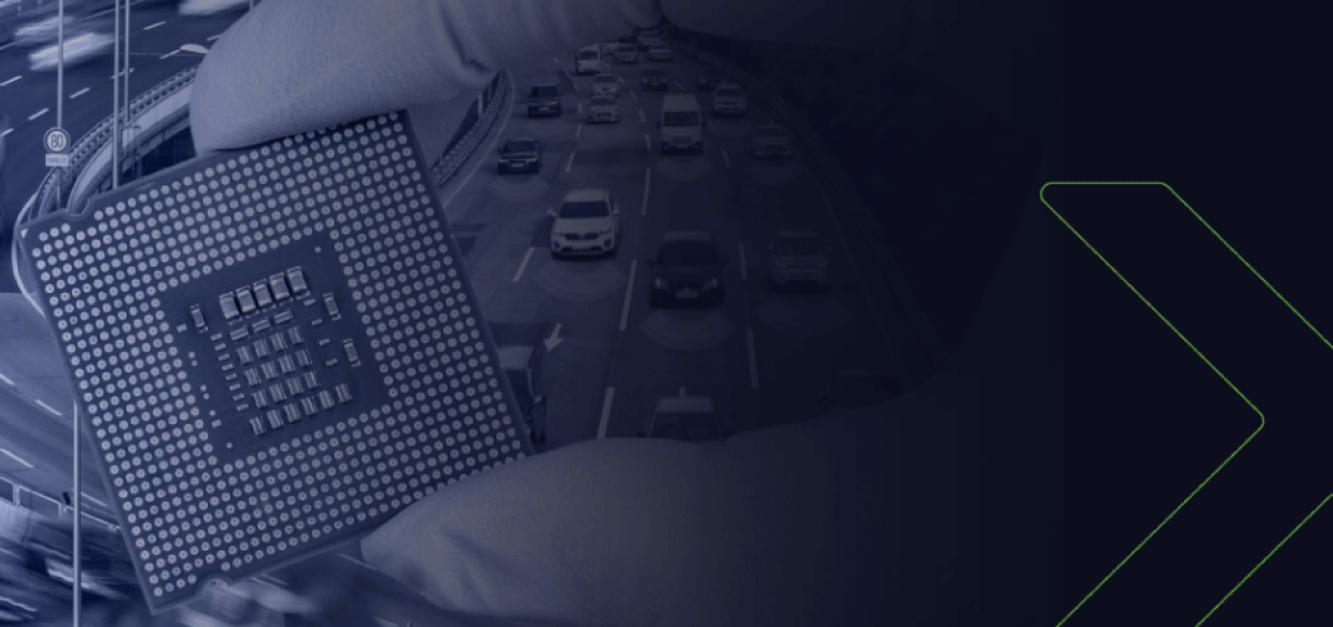 Mão com luva segurando chip semicondutor diante de rodovia com fluxo intenso de veículos, ilustrando escassez de insumos e impacto na cadeia automotiva