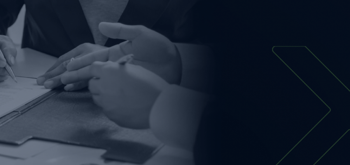 Profissionais analisando e assinando documentos durante reunião, simbolizando inovação e transformação digital na gestão tributária