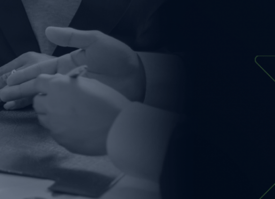 Profissionais analisando e assinando documentos durante reunião, simbolizando inovação e transformação digital na gestão tributária