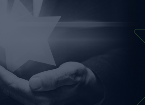 Mão segurando estrela simbolizando prêmio Automotive Business por indicação e reconhecimento por trabalho notável