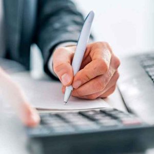 Profissional calculando tributos com caneta e calculadora, ilustrando a exclusão do ICMS da base de cálculo do PIS e COFINS