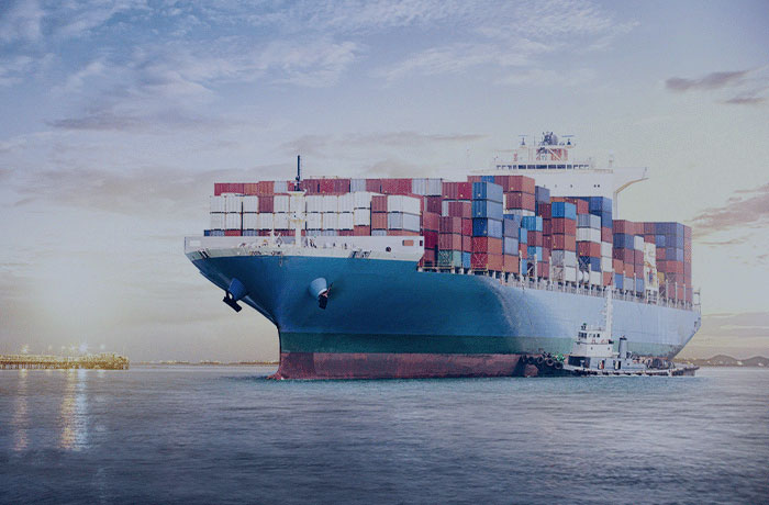 Navio cargueiro com contêineres no porto ao entardecer, representando regimes aduaneiros como alavanca estratégica para a competitividade no comércio exterior.
