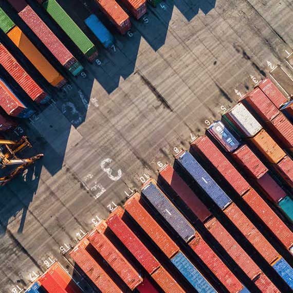 Vista aérea de contêineres organizados em terminal portuário, representando operações de comércio exterior e a aplicação de Transfer Pricing para gestão tributária internacional.
